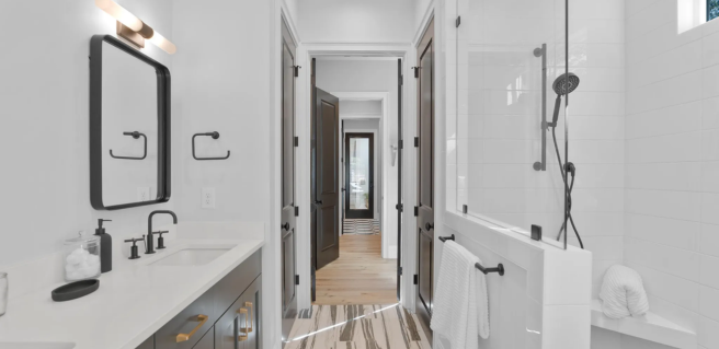 Verbena Model Home owner's suite bathroom with white countertops and black accents Parade of Homes