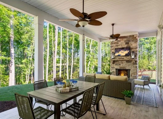 An outdoor living space with dining area and fireplace.