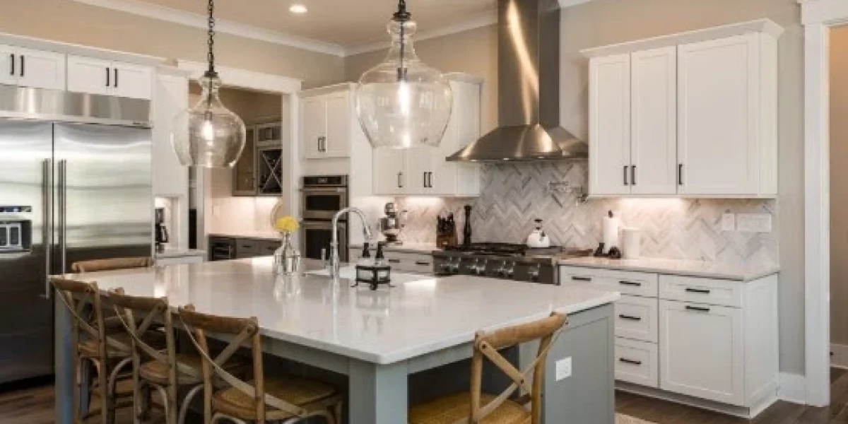 A white kitchen island with stools for family gatherings, surrounded by modern appliances and pendant lights in a cozy kitchen.
