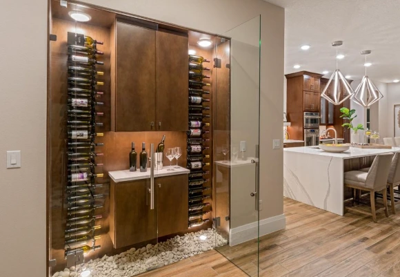 Glass-enclosed wine display with bottles and glasses, enhancing a kitchen area for retirees hosting wine tastings.