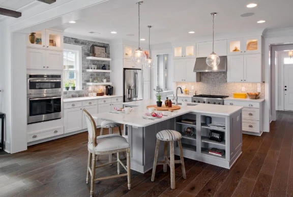 Bright kitchen with white cabinets, a large island, and pendant lights, perfect for retirees exploring new recipes.